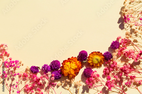 Flat background with dried flowers. Floral border and an empty space for text. Mockup for invitation or notice