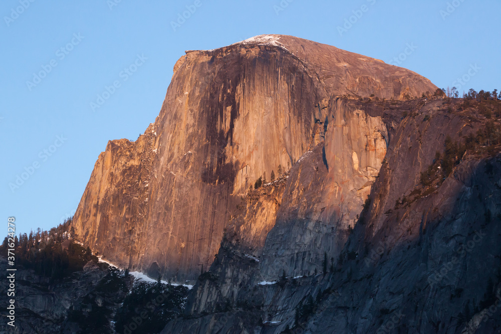 Half Dome with snow in the warm sunset light 