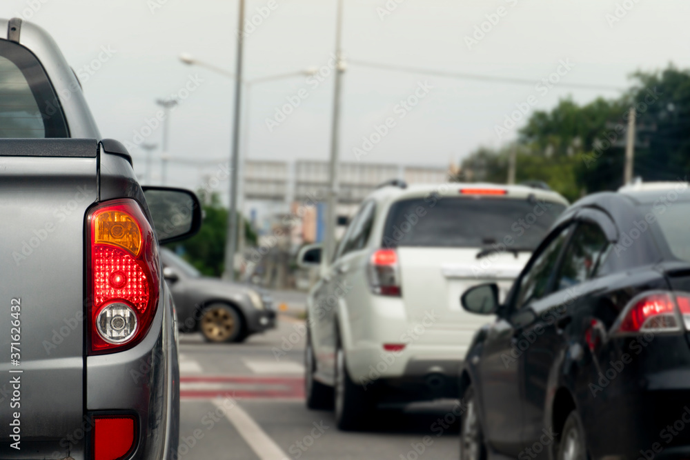 Luxury rear corner of pickup gray car on the road. Blurred image of car traffic across the street. Luxury rear corner of pickup gray car on the road. Blurred image of car traffic across the street.