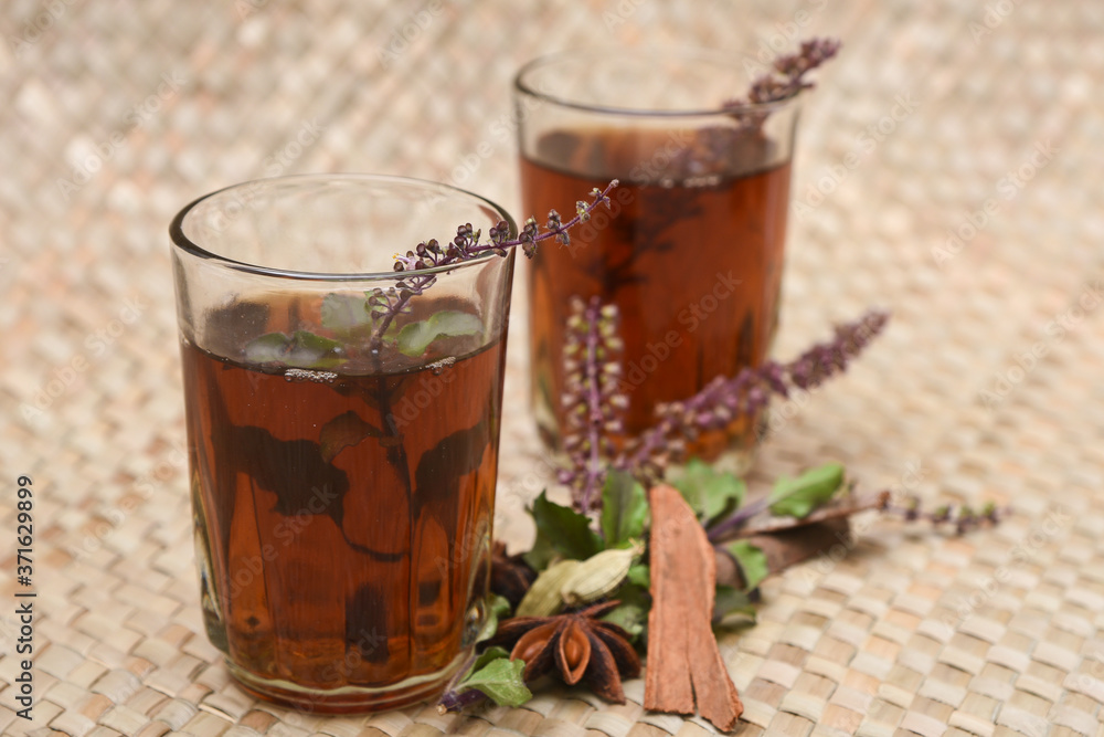 Indian Masala Chai black tea, traditional Tulsi herbal tea beverage with or without milk and spices Kerala India. Two cups organic ayurvedic herbal drink India, good in winter for immunity boosting. Indian Masala Chai black tea, traditional Tulsi herbal tea beverage with or without milk and spices Kerala India. Two cups organic ayurvedic herbal drink India, good in winter for immunity boosting.