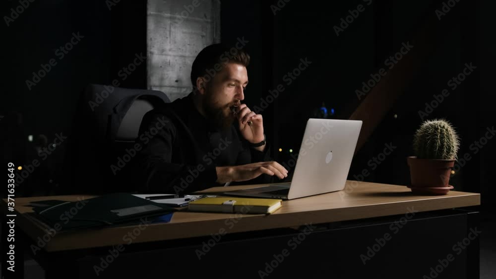 Tired businessman working in office at midnight, eating snack and drink a cup of coffee to work better. Night city view background. Tired businessman working in office at midnight, eating snack and drink a cup of coffee to work better. Night city view background.
