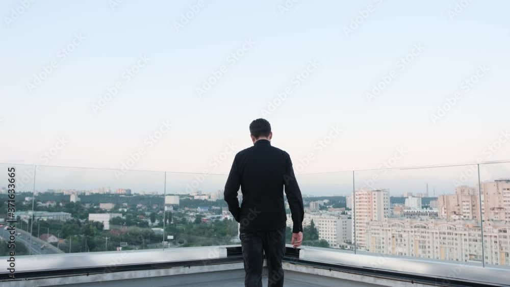 Man staying on a building roof and admiring the view, take a break from work. Man staying on a building roof and admiring the view, take a break from work.