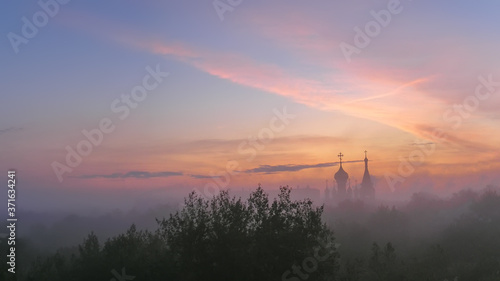 Soft focus silhouette of the Orthodox Church at sunrise in the morning fog.