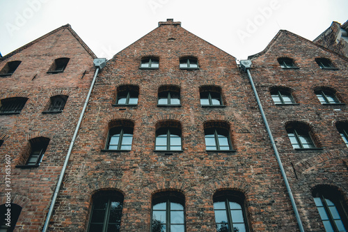 Fachada de ladrillo rojo con ventanas de una pared, paisaje urbano de Polonia