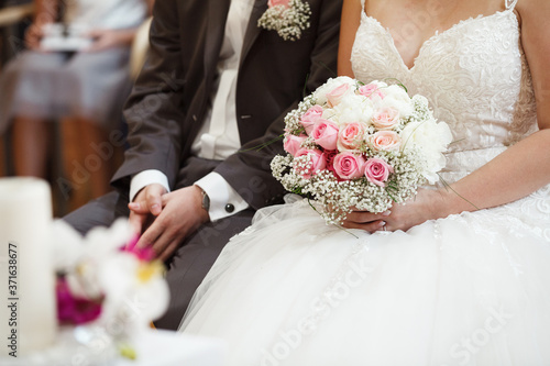 Brautpaar sitzt aufgeregt zur Hochzeit im Standesamt, Deutschland.