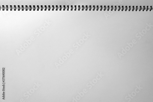 Blank sheet paper page on a spiral drawing pad, top view image.