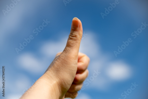  Thumbs up in the blue sky with cotton clouds