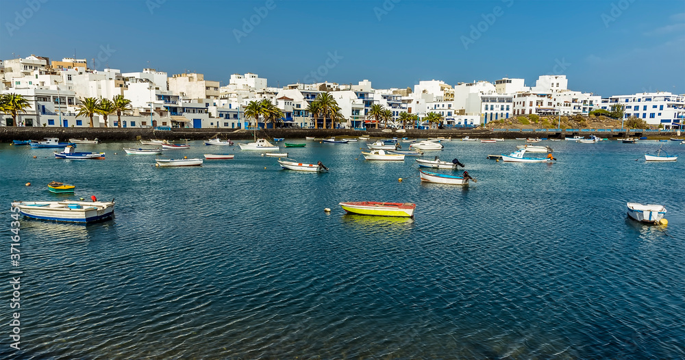 Fototapeta premium A view of small boats moored in the lagoon of Charco de San Gines in Arrecife, Lanzarote on a bright sunny afternoon