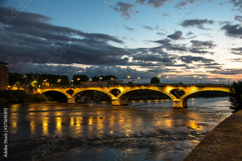 vue sur un pont illuminé enjambant un fleuve au crépuscule en ville 