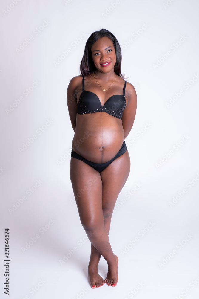 Fototapeta premium Chica negra embarazada posando en ropa interior