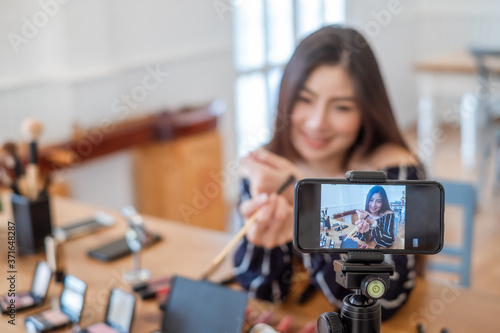 Young asian women live live selling cosmetics online. photo