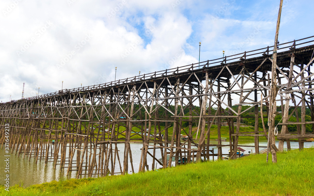 Fototapeta premium View of wooden bridge across the river and blue sky.