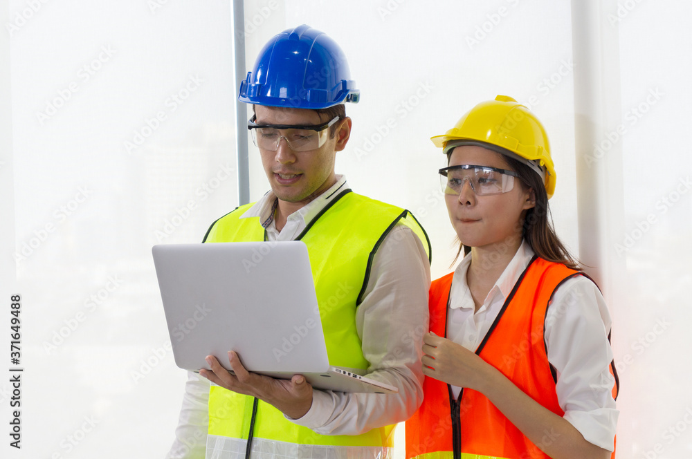 Young engineers are holding a laptop on the job site Professional working concepts Young engineers are holding a laptop on the job site Professional working concepts