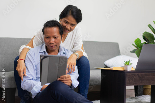 close up group of asian parent sitting in living room while using digital tablet for video call conference to connect and talking with family for new normal lifestyle and technology VOIP concept
