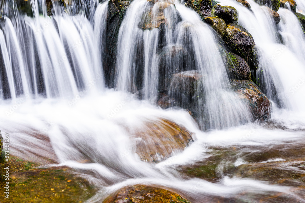 Fototapeta premium The stones under the waterfall, close-up waterfall as background.