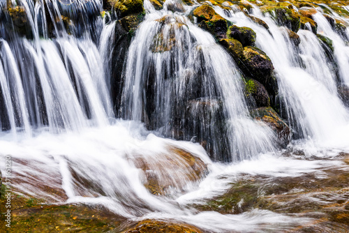 The stones under the waterfall, close-up waterfall as background.