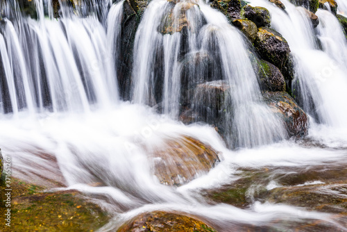 The stones under the waterfall, close-up waterfall as background.