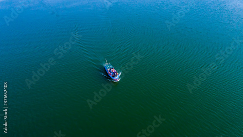 Aerial drone view of a ship in green blue water
