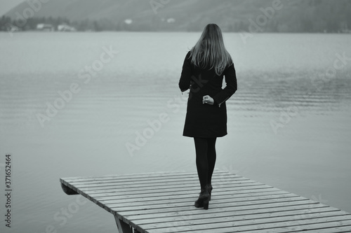 the sad woman in front of the lake in autumn photo