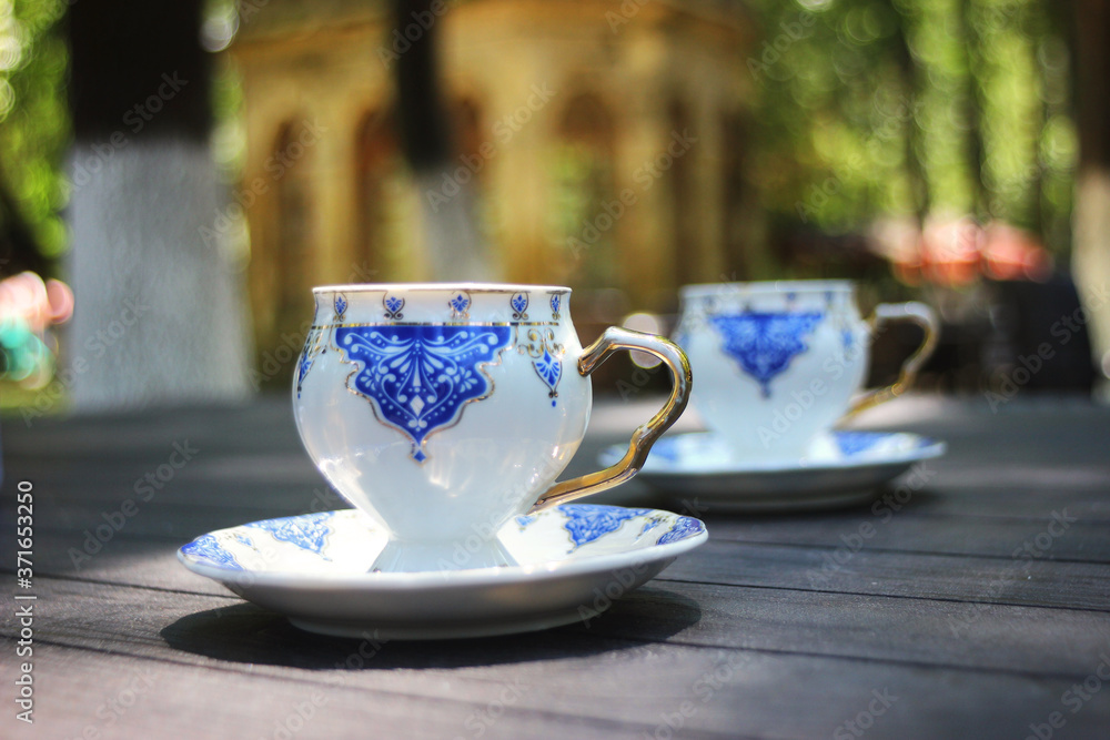 Two cups of traditional Turkish coffee standing on the table in front of the oriental and historical building with bokeh effects in the background Two cups of traditional Turkish coffee standing on the table in front of the oriental and historical building with bokeh effects in the background