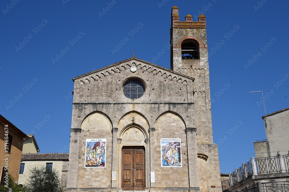 Basilika Sant'Agata in Asciano vor strahlend blauem Himmel