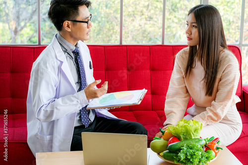 Asian medical doctor advised young female patient on  nutrition and healthy diet eating to prevent virus pandemic in clinical hospital. Doctor and patient concept. medicine and health care concept. photo