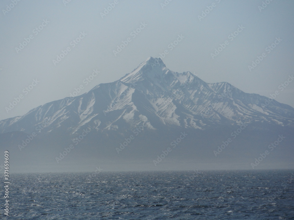 snow covered mountains over ocean