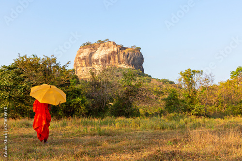 Monk with the Sigiriya Rock in the background in Sri Lanka