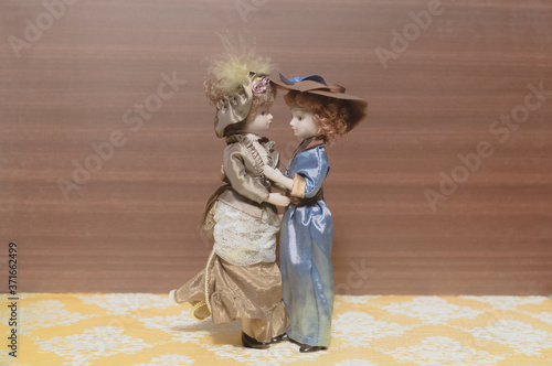 ceramic porcelain dolls in vintage dress. Lady dolls standing on the wooden background. Vintage LGBT lesbians concept