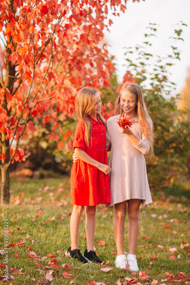 Little adorable girls outdoors at warm sunny autumn day Little adorable girls outdoors at warm sunny autumn day