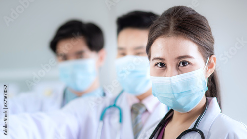 Close-up shot of an Asian woman doctor wearing a medical mask to protect Contagious disease during treatment during the coronavirus or covid-19 is spreading.