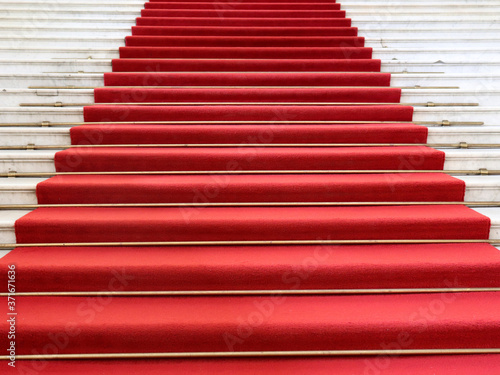 Red carpet on the white marble staircase. Rise up. Go up.