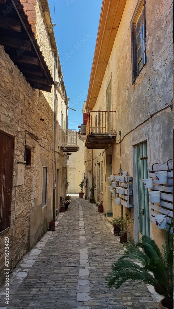 narrow street in the old town. picturesque narrow street lined with stone houses with wooden windows and doors in a village in cyprus