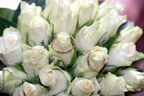 Wedding rings and white roses