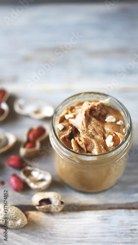 Selective focus. Peanut butter in a jar. Peanuts in the skin.