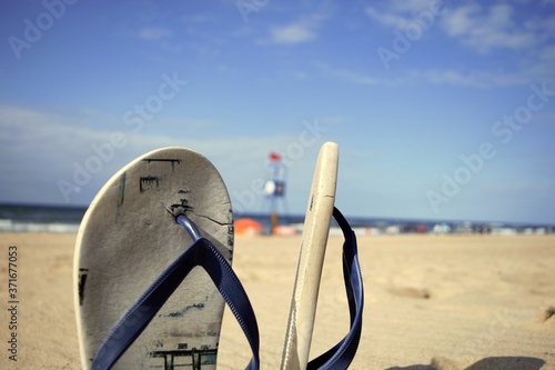 Fotografie Foreground beach sandals stuck in the sand