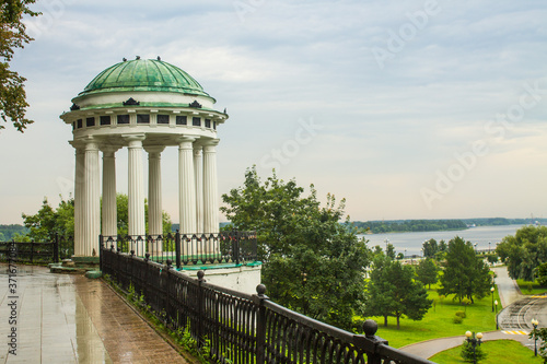 white rotunda with columns on the embankment on a cloudy summer day and space fo Fototapeta