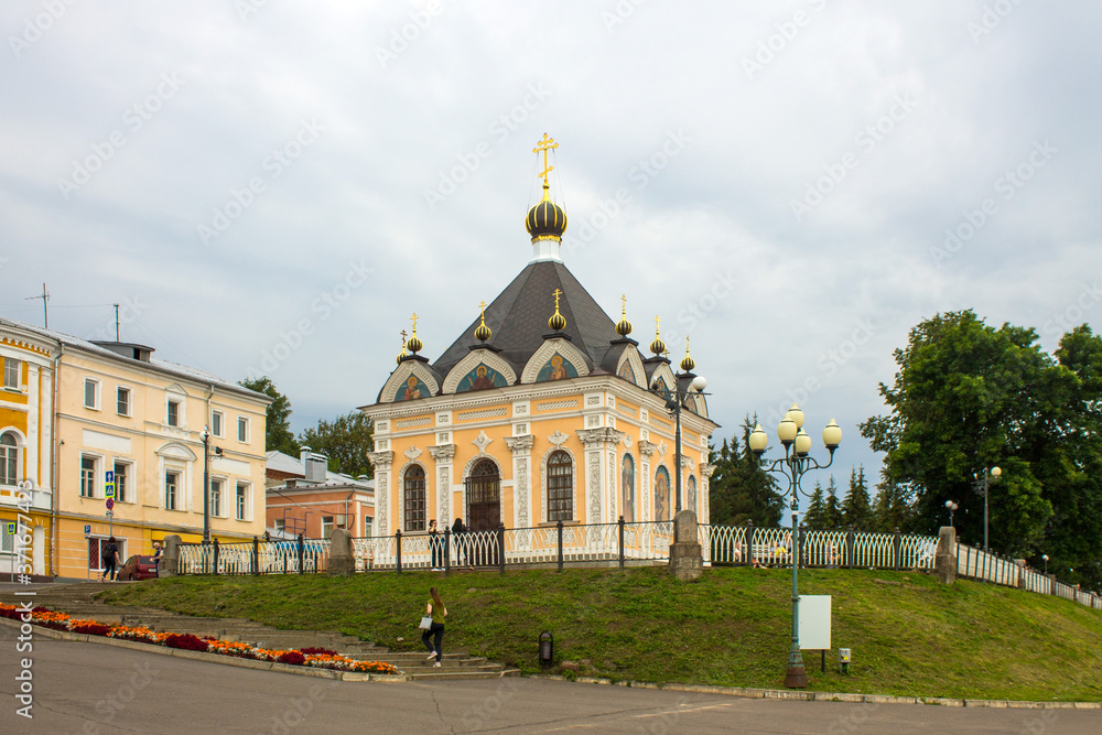 St. Nicholas chapel on a hill with green grass against a cloudy sky close-up on a summer day in Rybinsk Russia