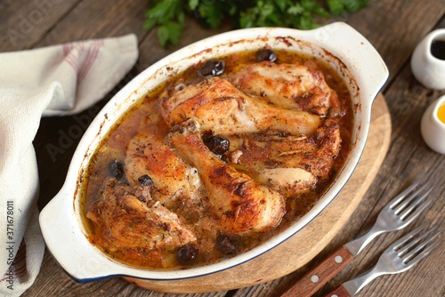 Baked chicken drumsticks and thighs with onions, garlic, olives and tomatoes. Organic food.