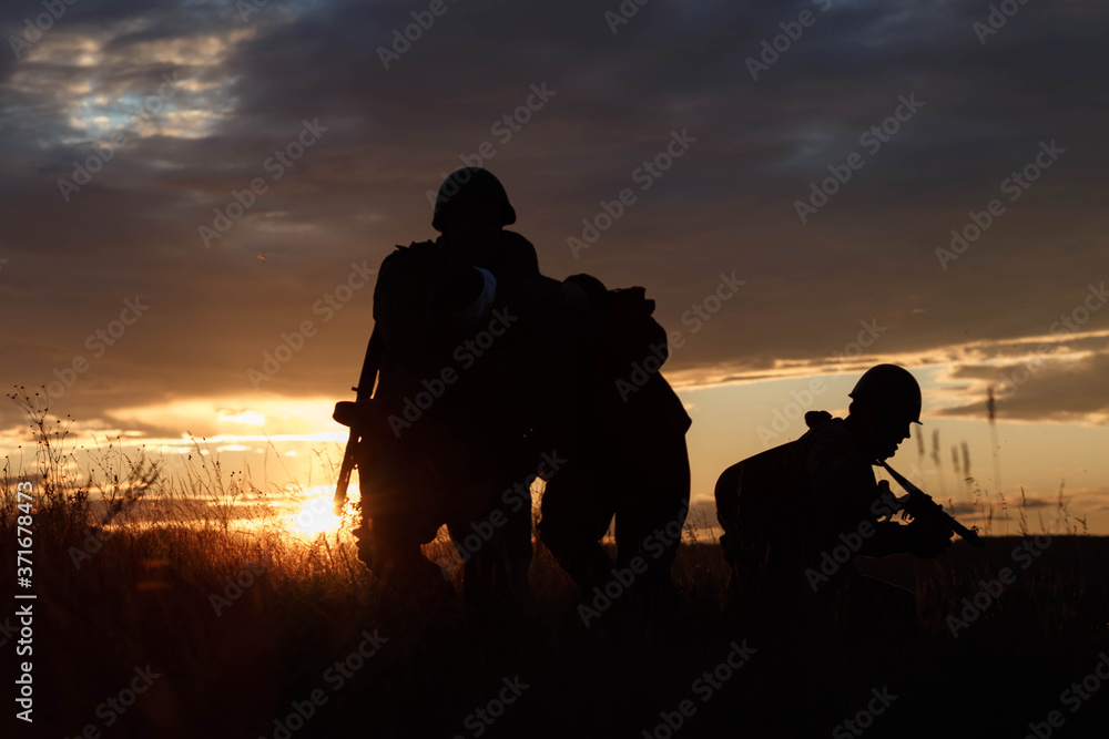 silhouettes of soldiers against the sunset sky