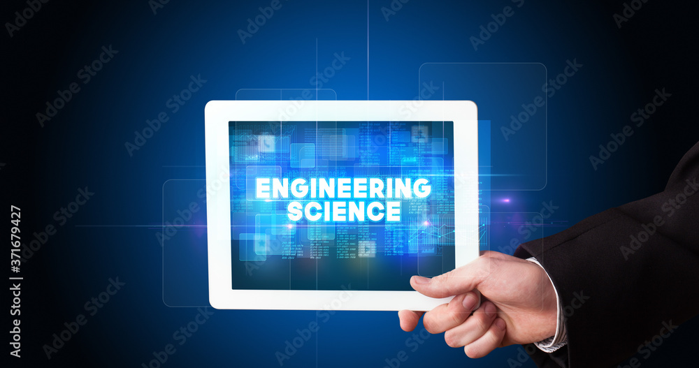 Young business person working on tablet and shows the inscription: ENGINEERING SCIENCE Young business person working on tablet and shows the inscription: ENGINEERING SCIENCE