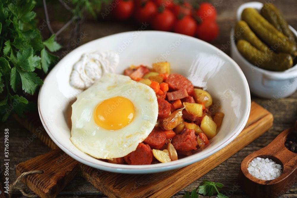 Fried potatoes with smoked meat and chorizo with garlic, onions, carrots and eggs. Fried potatoes with smoked meat and chorizo with garlic, onions, carrots and eggs.