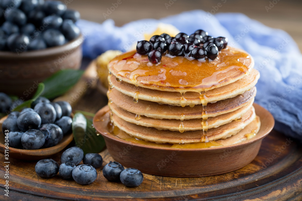 Blueberries in a plate and pancakes, on an old background. Blueberries in a plate and pancakes, on an old background.