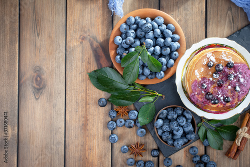 Fototapeta Naklejka Na Ścianę i Meble -  Blueberries in a plate and pancakes, on an old background.