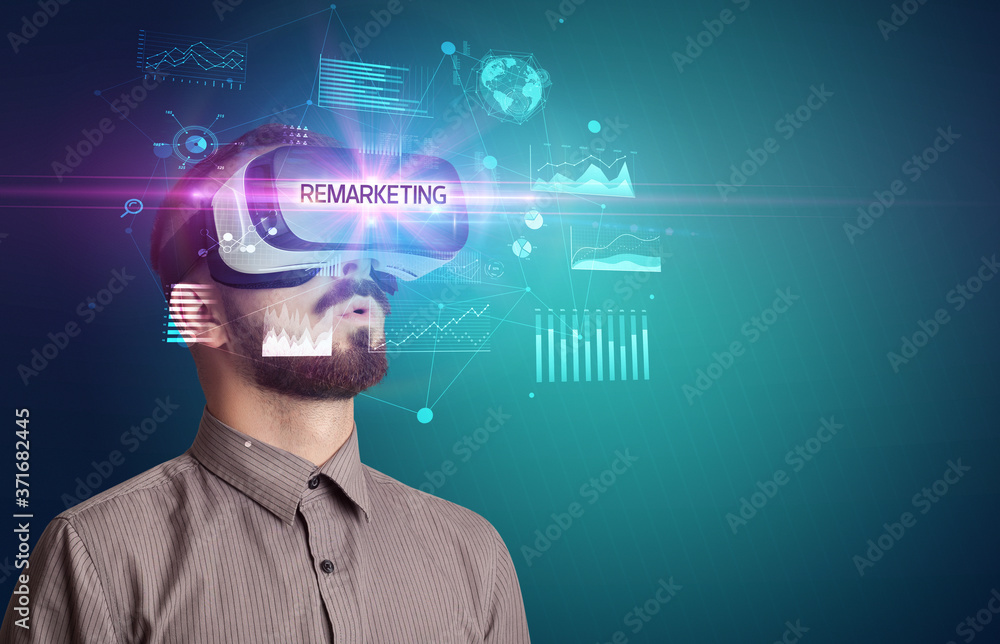 Businessman looking through Virtual Reality glasses with REMARKETING inscription, new business concept Businessman looking through Virtual Reality glasses with REMARKETING inscription, new business concept