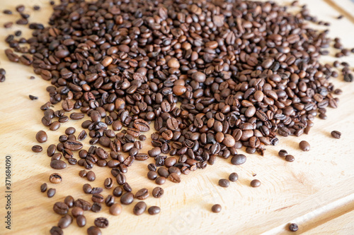 Coffee grains on wooden table, with natural light