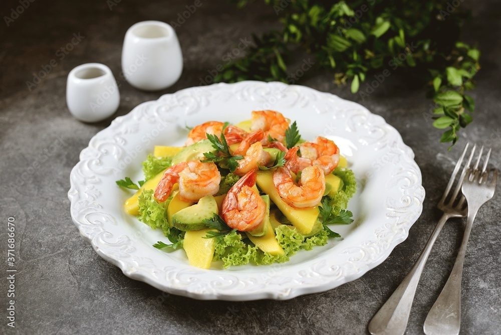 Salad with shrimp tails, lettuce, avocado, mango slice, parsley, olive oil and lemon juice. Healthly food. Salad with shrimp tails, lettuce, avocado, mango slice, parsley, olive oil and lemon juice. Healthly food.