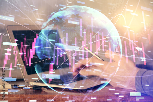 Double exposure of man's hands holding and using a digital device and forex graph drawing. Financial market concept.