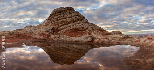 Strange rocks reflect in a watery pool in the desert of Arizona at sunset.