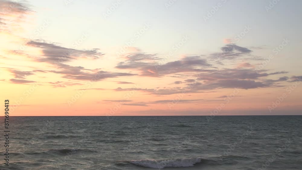 Large sky. Orange pink yellow skyline at dusk with the waves rolling and beautiful clouds. Wide static. Real-time. Lake Huron Large sky. Orange pink yellow skyline at dusk with the waves rolling and beautiful clouds. Wide static. Real-time. Lake Huron